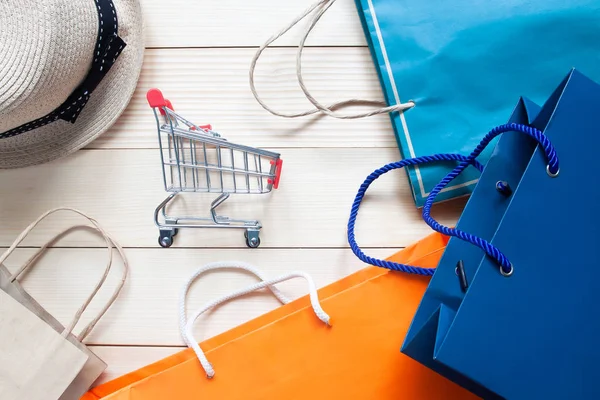 Creative ploché ležela nakupování koncept s nákupním košíkem a barevné nákupní tašky — Stock fotografie