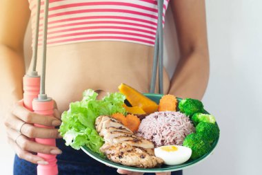 Fitness Spor donatımı tabak sağlıklı yemek tutan kadınla. Pirinç ve sebze ızgara tavuk göğsü