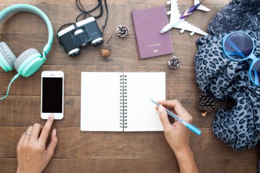 Cep telefonu kullanma ve boş defter üzerinde yazma kadının eller en iyi görünümü seyahat kavramı, alay için mobil uygulama