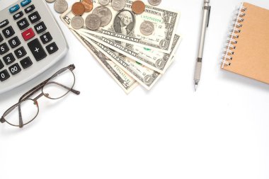 Beyaz arka plan üzerinde çalışma masası hesap makinesi, kağıt para ve para ile üstten görünüm