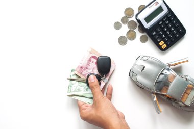 Tay banknot ve araba anahtarı, otomobil kredisi veya araba ekonomi kavramı tutan adam el