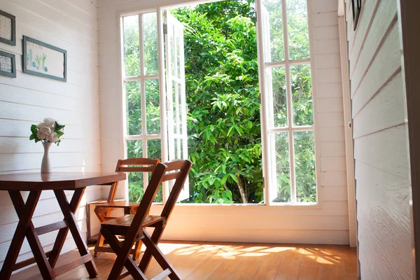 Living room with big window garden view, country style with wooden furniture