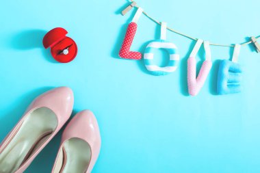 Nişan yüzüğü ve mavi renk zemin, üstten görünüm üzerine gelin aksesuarları. Aşk kavramı