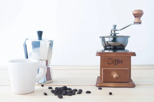 Coffee pot, Coffee grinder and coffee beans on wooden table