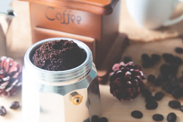 Ground coffee in coffee pot with coffee beans on table, Close up