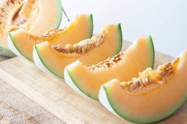 Taze kavunlar ahşap kesme tahtası üzerinde dilimlenmiş. Sağlıklı meyve. Seçici odak