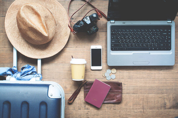 Creative flat lay Travel concept. Laptop computer on table with traveler's items and smartphone