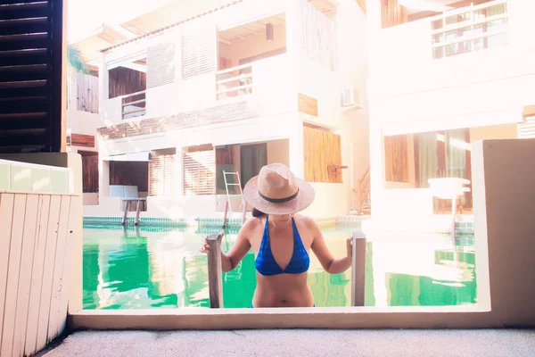 Mulher asiática usando biquíni e chapéu de palha na piscina. conceito de férias de viagem — Fotografia de Stock