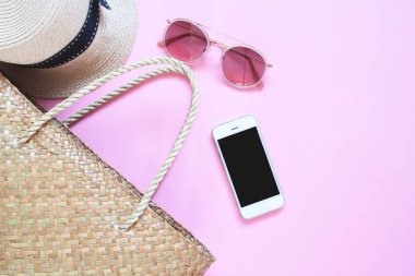 Düz pembe renk üstünde hareket eden aygıt ile yaz aksesuarları, göklere