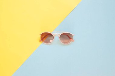Pastel renk tonu arka plan üzerinde trendy güneş gözlüğü yaratıcı düz lay.