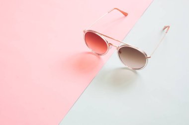 Pastel renk tonu arka plan üzerinde trendy güneş gözlüğü. Moda veya en az kavramı
