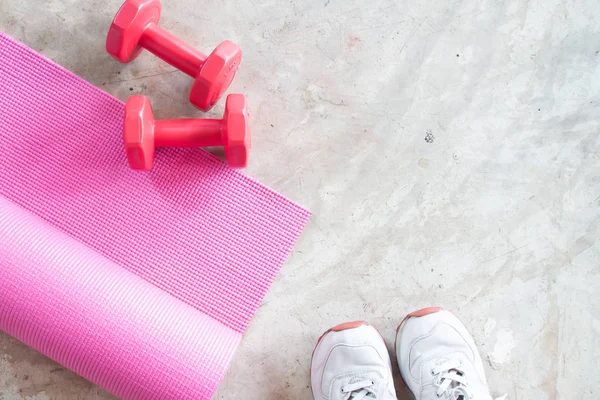 Selfie de pieds fille sportive avec tapis de yoga et haltères sur concre Image En Vente