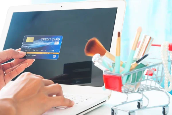 Hands holding credit card and using laptop computer. Beauty online shopping, E-payment or internet banking — Stock Photo, Image