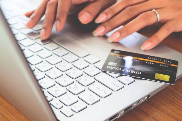 Woman hands using laptop computer with plastic credit card on keyboard. Selective focus . Online shopping, paying, buying, e-payment and technology concept. — Stock Photo, Image