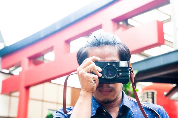 Hipster hombre con una cámara en la ciudad de Japón. Viajar. Foto vintage — Foto de Stock
