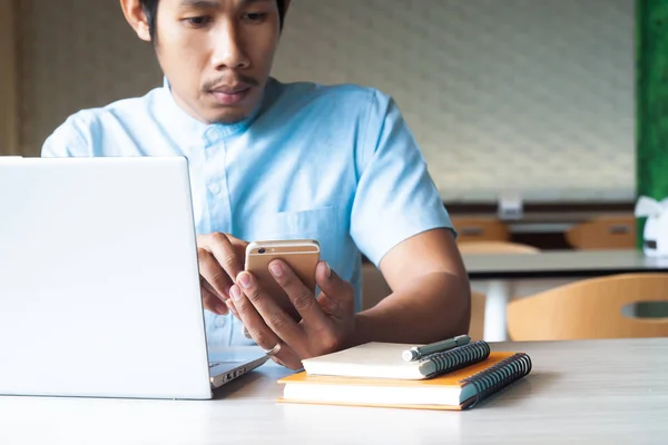 Cara asiático usando telefone inteligente e computador portátil para conteúdo de marketing. Marketing online. Conceito de negócio e tecnologia Fotos De Bancos De Imagens Sem Royalties