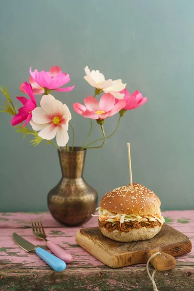 Hamburger di maiale tirato con fiori di carta su tavola di legno — Foto Stock