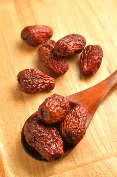 Dried jujube fruits on wooden plate