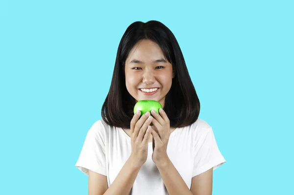 Uma jovem segurando uma maçã verde com o fundo verde — Fotografia de Stock