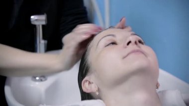 Kuaför Saç yıkar. Kuaför saç modeli genç kız için yapar.