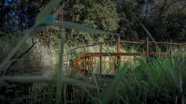Puente de madera sobre un pequeño río — Foto de Stock