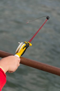 Childs'ın el üzerinde küçük bir olta balık tutuyor. Ozernaya balıkçılık.