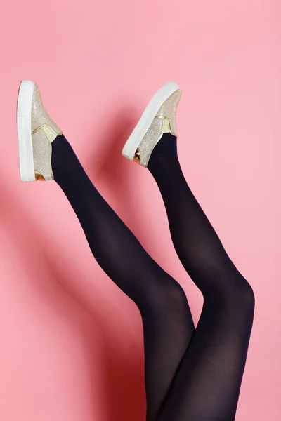 Ноги Молодой Белой Женщины Черных Колготках Золотых Туфлях Розовом Фоне — стоковое фото