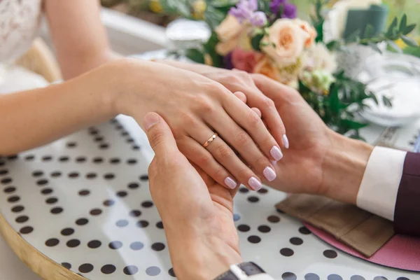 Närbild Bröllop Händer Med Ringar Och Bukett Lögn Bordet — Stockfoto