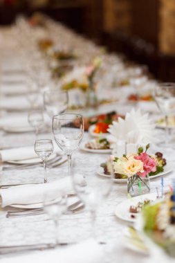 Ziyafet masasına servis edilmiş. Peçeteli, bardaklı ve salatalı şarap bardakları.