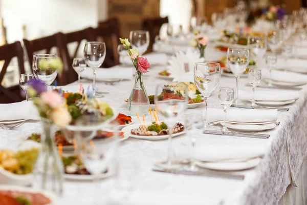 Ziyafet masasına servis edilmiş. Peçeteli, bardaklı ve salatalı şarap bardakları.