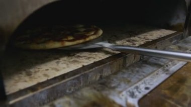 Cook bitmiş pizza fırından ortaya çıkarır