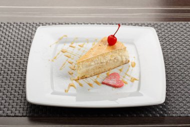 Tepesi ve kiraz ile dekore edilmiş lezzetli lezzetli peynirli kek dilimi