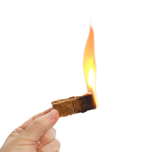 バーベキューの固体 Firelighter を燃焼のタイルを保持する手 白い背景に分離 — ストック写真