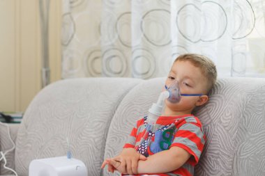 Beyaz çocuk öksürük durdurmak için ilaç içeren çiftler inhales. Tıbbi prosedürler. Astım ilacı. Solunum tıp. Bronşit, astım sağlık ekipmanları. Ev tedavi kavramı.