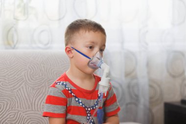 Beyaz çocuk öksürük durdurmak için ilaç içeren çiftler inhales. Tıbbi prosedürler. Astım ilacı. Solunum tıp. Bronşit, astım sağlık ekipmanları. Ev tedavi kavramı.