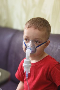 Beyaz çocuk öksürük durdurmak için ilaç içeren çiftler inhales. Tıbbi prosedürler. Astım ilacı. Solunum tıp. Bronşit, astım sağlık ekipmanları. Ev tedavi kavramı.