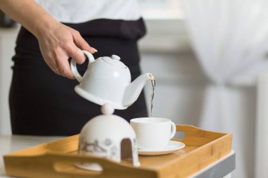 Çay dökülen bir kadın yan görünüm