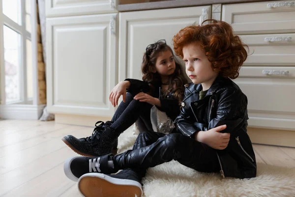 Oğlan ve kız arkadaşlar birlikte yere oturun. Çocuk kıza deli.