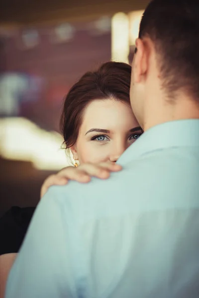 Retrato de uma jovem mulher olhando por trás do ombro do namorado — Fotografia de Stock