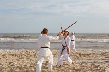 Bir sporcu grubuz eğitim karate deniz sahilinde