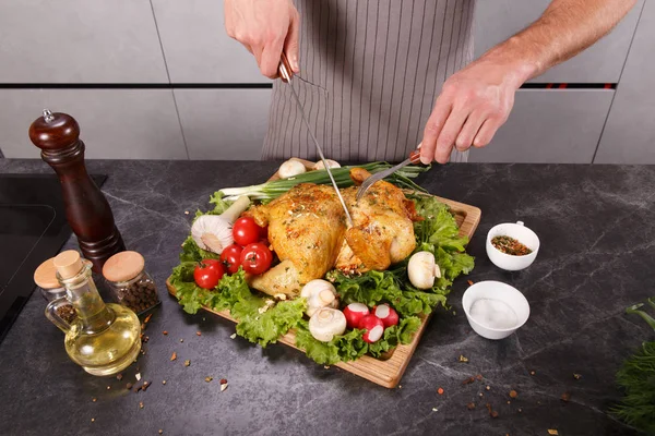 Ręce szefa człowieka cuting pieczone kurczaka z warzywami — Zdjęcie stockowe