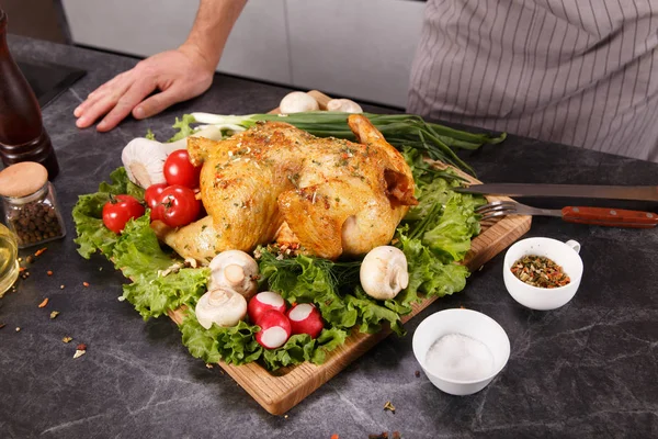 Ruce náčelníka řezala pečené kuře se zeleninou — Stock fotografie