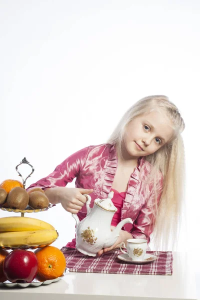 Schönes Mädchen gießt Tee in eine Tasse — Stockfoto