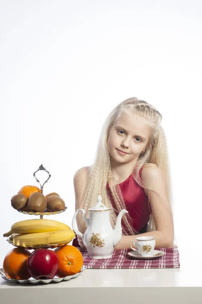 Kleines Mädchen sitzt am Tisch — Stockfoto