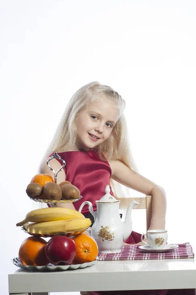 Little girl sitting at the table — Stock Photo, Image