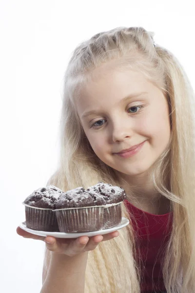 Girl holds chocolate muffins — Stock Photo, Image