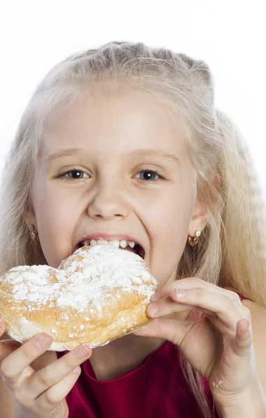 Mädchen beißt in herzförmigen Keks — Stockfoto