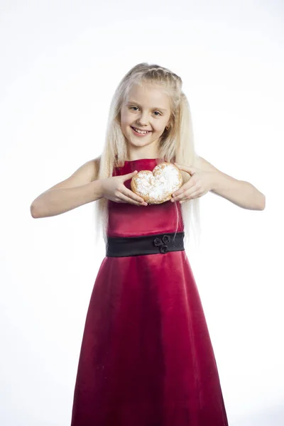 Chica sosteniendo una galleta en forma de corazón —  Fotos de Stock