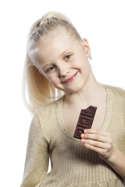 Vacker flicka äta choklad. — Stockfoto