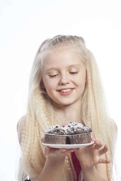 Girl holds chocolate muffins — Stock Photo, Image